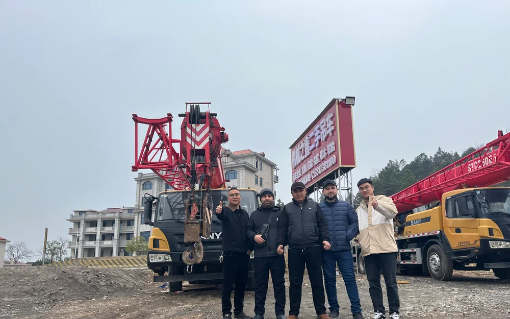 Overseas buyers inspecting mobile cranes at an equipment yard