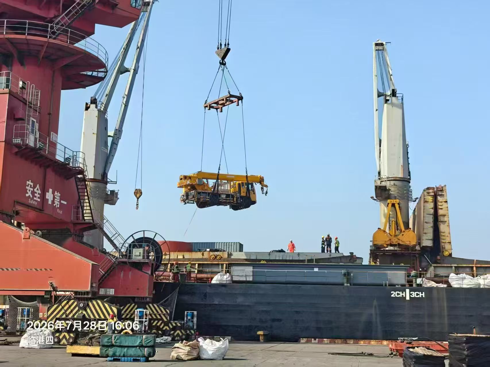 Truck crane being lifted over a cargo vessel during breakbulk loading